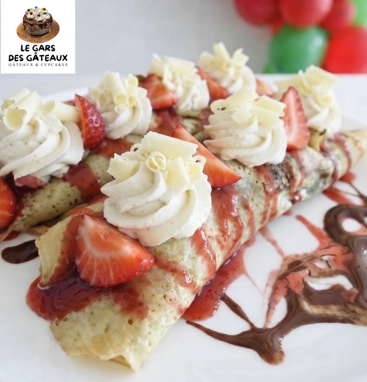 Crêpes roulées garnies de fraises, de crème fouettée à la vanille, de coulis aux fraises et de coulis au chocolat